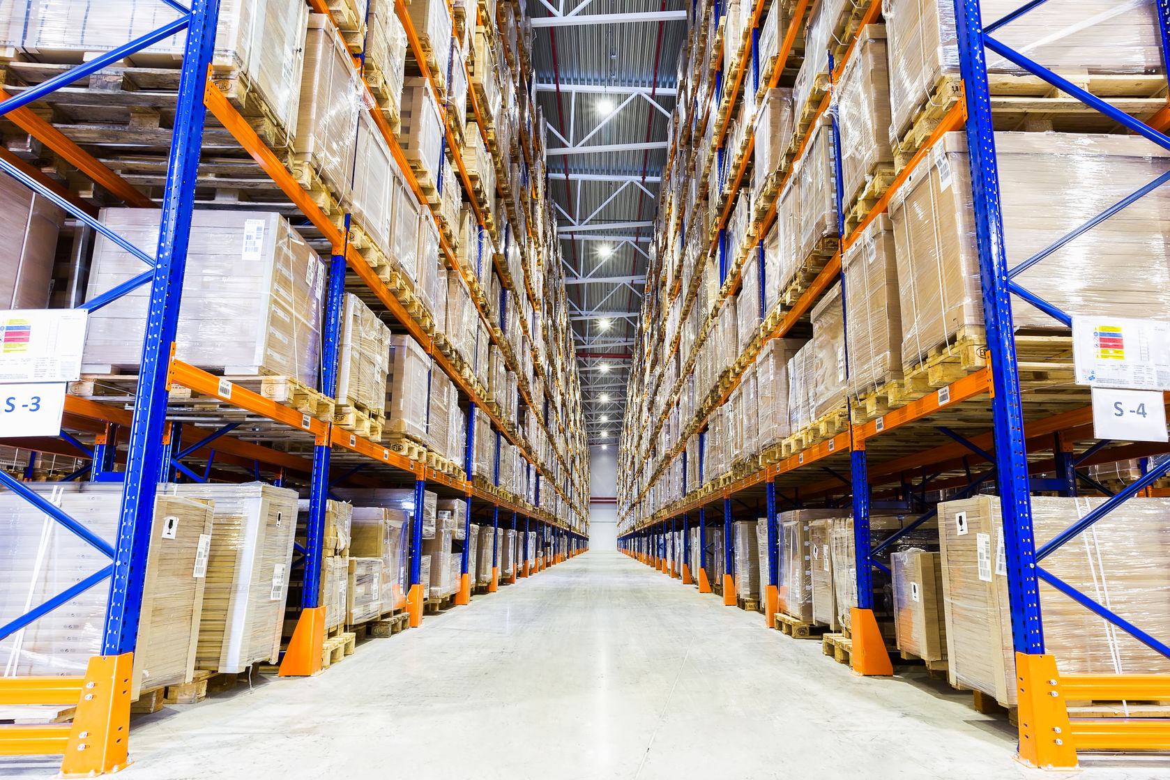 Warehouse aisle with high racking full of palletised goods